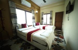 Tempat tidur dalam kamar di Hotel Flycatcher Chitwan- A jungle Safari Home