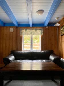 un sofá de cuero en una habitación con ventana en Trollstigen Camping and Gjestegård, en Åndalsnes