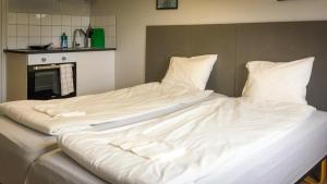 een groot bed met witte lakens en kussens bij Liz Motell in Sundsvall