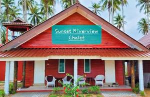 a red house with a sign that reads sunset riverview chapel at PULANG RESORT in Setiu