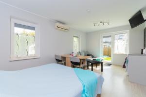 a bedroom with a bed and a desk and a table at Villa del Sol in Sztutowo