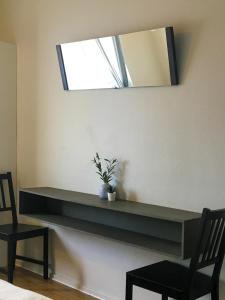 uma prateleira numa parede com um espelho e uma planta em Liz Motell em Sundsvall