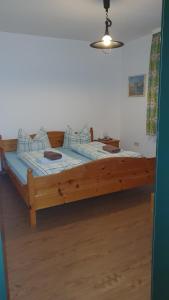 Cama grande de madera en habitación con suelo de madera en Haus Christine, en Halblech