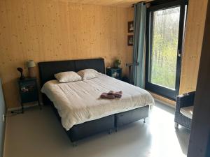 een slaapkamer met een bed met twee schoenen erop bij Villa Meijer in Almere