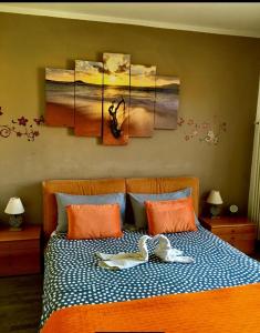 a bedroom with a bed with some paintings on it at Appartamento Elena in Garda