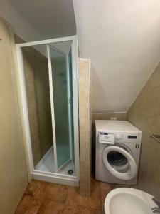 a bathroom with a shower and a washing machine at Cielo e terra casina panoramica in Collepardo