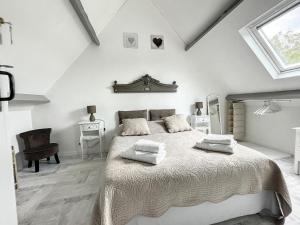 a white bedroom with a large bed and a window at Chambres d'Hôtes La Clef des Champs in Montpinchon