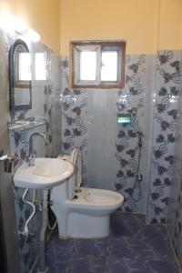 e bagno con lavandino, servizi igienici e doccia. di Hotel Flycatcher Chitwan- A jungle Safari Home a Sauraha