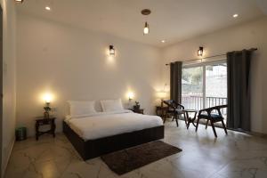 um quarto com uma cama grande e uma varanda em Divine Retreat em Mukteshwar