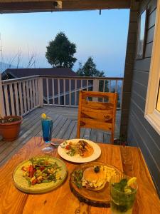 uma mesa com dois pratos de comida num convés em Divine Retreat em Mukteshwar