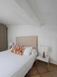 een slaapkamer met een bed en een nachtkastje met een lamp bij A CASA ROSSA , Le Thym in Saint-Paul-de-Vence