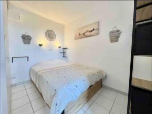 een slaapkamer met een bed in een witte kamer bij Appart vue mer et Esterel-Piscine in Saint-Raphaël