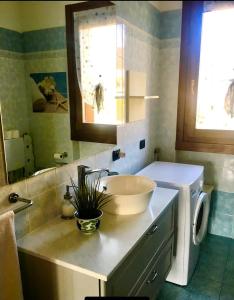 a bathroom with a sink and a washing machine at Appartamento Elena in Garda