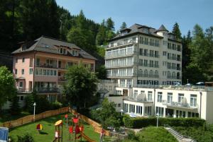 un grupo de edificios y un parque infantil en una ciudad en MONDI Hotel Bellevue Gastein en Bad Gastein