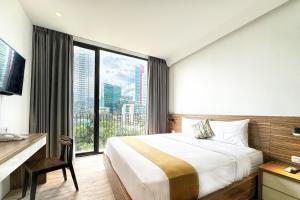 a bedroom with a large bed and a large window at Rasuna Icon Hotel in Jakarta