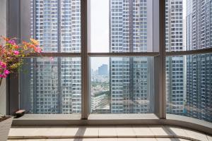 ein Fenster mit Blick auf eine Stadt mit hohen Gebäuden in der Unterkunft Isabelle Luxury Apartment inside Landmark 81 Tower in Ho-Chi-Minh-Stadt