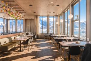 um restaurante com mesas e cadeiras e janelas grandes em Enter St Elisabeth Suites & Spa em Tromsø