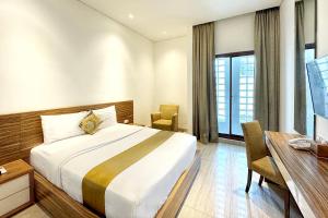 a hotel room with a bed and a table and a desk at Rasuna Icon Hotel in Jakarta