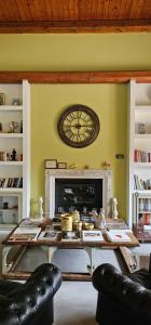 a living room with a table and a clock on the wall at Relais Casa Mirabile in Menfi