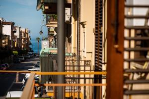 - un balcon donnant sur une rue avec des bâtiments dans l'établissement SuiteSicily Rooms Vasca Idromassaggio Palermo, à Altavilla Milicia