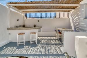a balcony with a bar and stools on a white wall at Kentra House - Parikia center in Parikia +12 photos