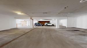 an empty parking garage with two cars parked in it at Hotel Toliar in Štrbské Pleso