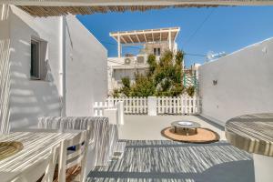 a white house with a white fence and a table at Kentra House - Parikia center in Parikia