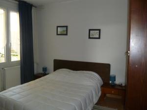 Gîte des bords de Rance في Langrolay: سرير في غرفة نوم مع صورتين على الحائط