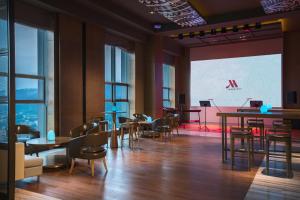 a restaurant with tables and chairs and a large screen at Chongqing Marriott Hotel in Chongqing
