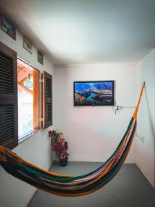 a hammock hanging on a wall in a room at Beco do Preá - Kite Apartamentos e Suítes Beira Mar in Prea