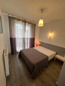 a bedroom with a bed in front of a window at Villa Marmillons in Aix-les-Bains