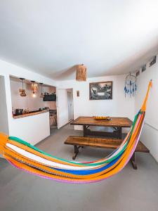 a colorful hammock in a room with a table at Beco do Preá - Kite Apartamentos e Suítes Beira Mar in Prea