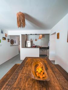 un plato de naranjas en una mesa de madera en la cocina en Beco do Preá - Kite Apartamentos e Suítes Beira Mar, en Prea