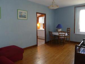 Gîte des bords de Rance في Langrolay: غرفة معيشة مع طاولة وغرفة طعام