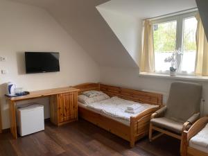 a bedroom with a bed and a desk and a chair at Penzion Ameryka in Jablunkov