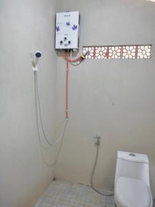 een badkamer met een wit toilet en een douche bij Omah joglo RedPartner 