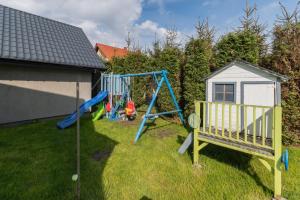 a playground in a yard next to a house at Villa del Sol in Sztutowo