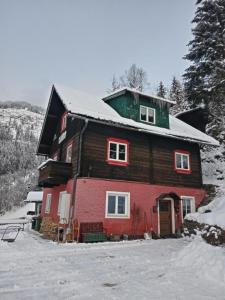 Una gran casa de madera con nieve encima. en Chalet Rosemarie, en Bad Gastein