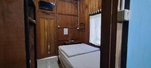 een kleine kamer met een klein bed en een raam bij Omah joglo RedPartner 