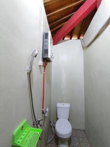 een kleine badkamer met een toilet en een telefoon bij Omah joglo RedPartner 