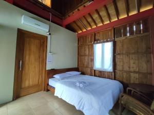 een slaapkamer met 2 bedden en een raam en een deur bij Omah joglo RedPartner 