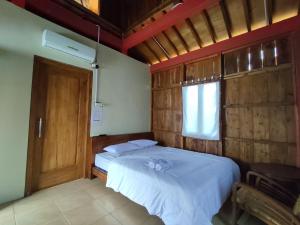 a bedroom with two beds and a window and a door at Omah Joglo Sukorejo RedPartner in Sukareja