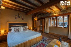 a bedroom with a bed and a large window at StayVista at The Manor in Manāli