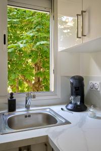 a kitchen counter with a sink and a window at Appartement Paisible Climatisé in Malakoff