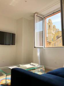 een woonkamer met een glazen salontafel en een raam bij Terrazzo in Bastia