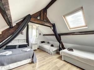 um quarto no sótão com 2 camas e uma janela em Gite La Clef des Champs em Montpinchon