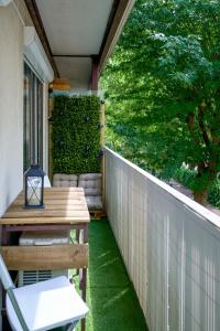 a patio with a wooden table and a fence at Appartement Paisible Climatisé in Malakoff