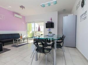 Un comedor con una mesa de cristal y sillas negras. en Villa Ava, en Šibenik