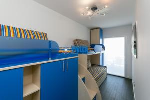 Habitación con literas azules y techo. en Laguna Park, en Lido di Jesolo