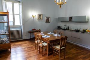 a dining room with a table and a kitchen at Palazzo Crescimbeni in Bevagna